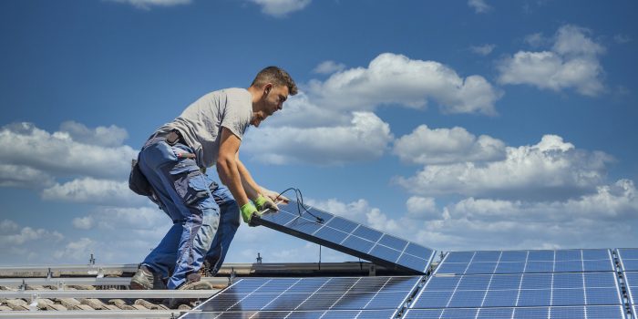 Installing solar photovoltaic panel system. Solar panel technician installing solar panels on roof. Alternative energy ecological concept.