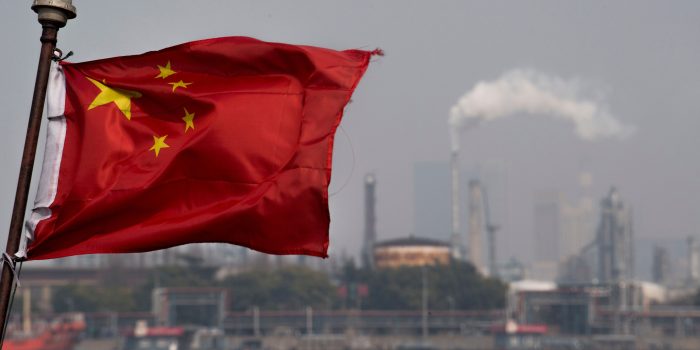 This picture taken on March 22, 2018 shows a Chinese flag fluttering in front of the Shanghai Gaoqiao Company Refinery in Shanghai. - China launched yuan-denominated oil futures contracts on March 26, marking the first time foreign investors will have access to Chinese commodity futures as the world's top crude importer seeks greater influence over global prices. (Photo by Johannes EISELE / AFP) (Photo by JOHANNES EISELE/AFP via Getty Images)